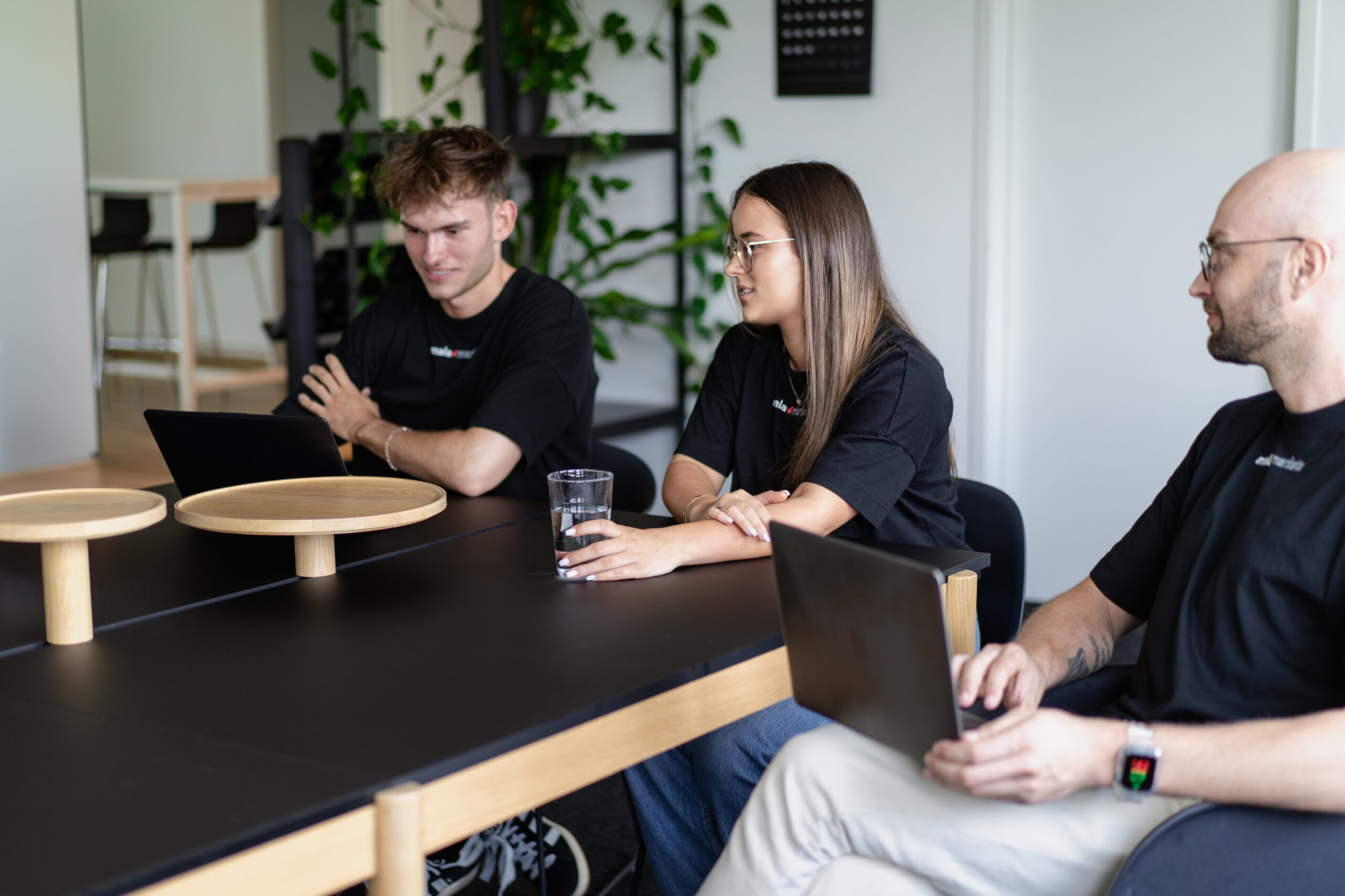 Team sitzt gemeinsam am Meeting Tisch im Büro