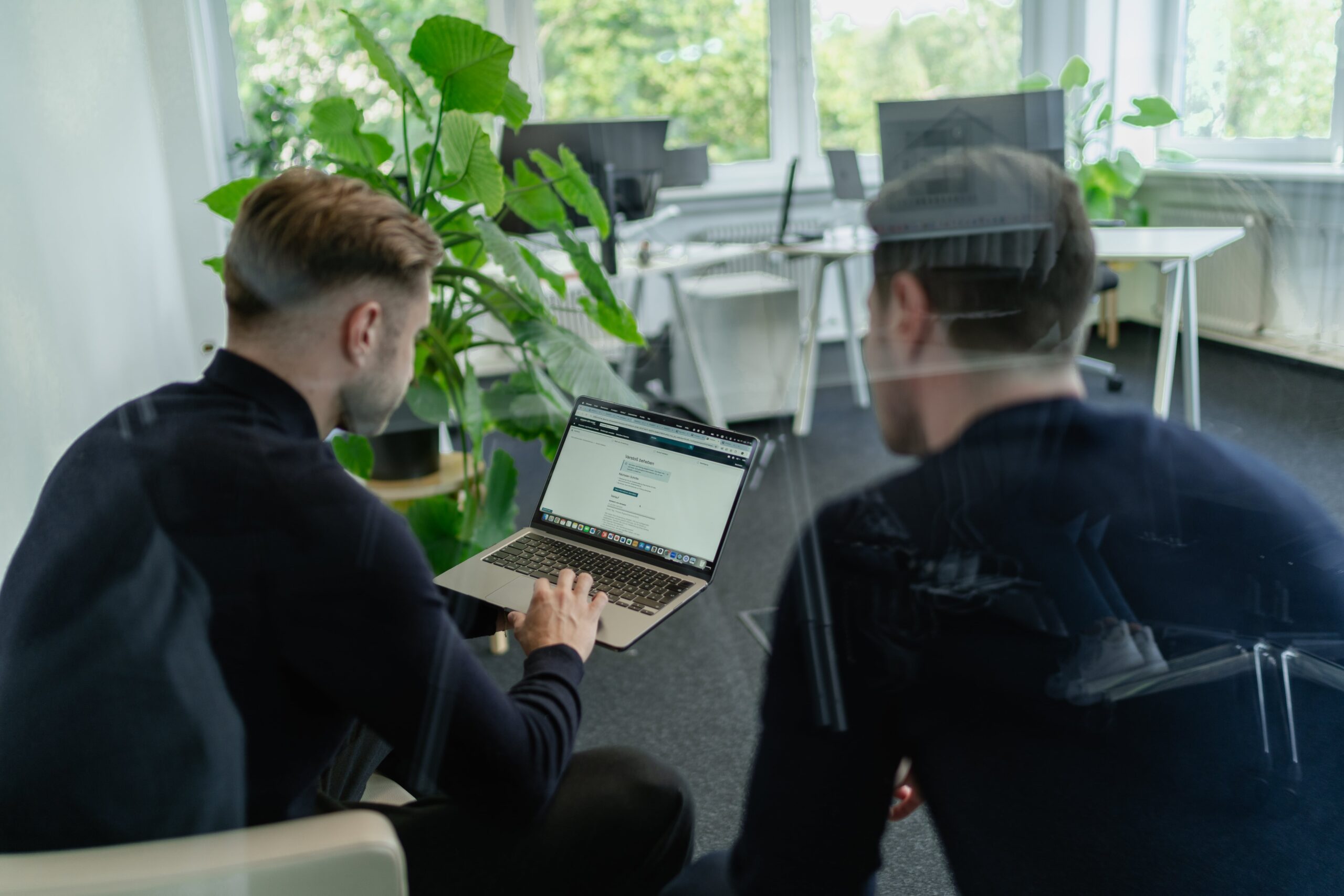 Zwei Personen dem Laptop zugerichtet